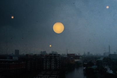 Scenic view of moon in city against sky at night