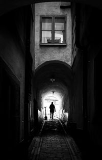 Rear view of man walking in tunnel