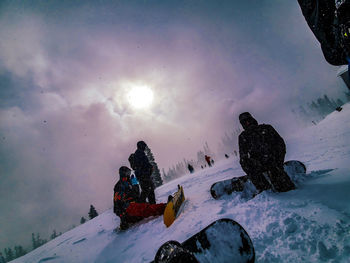 People on snow covered mountain against sky