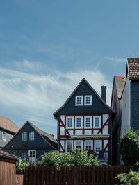 Houses by buildings in town against sky