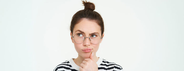 Portrait of young woman against white background