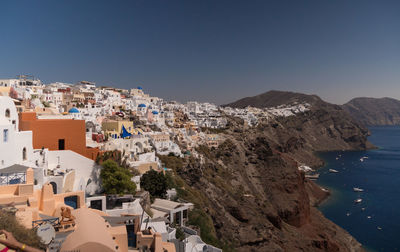 High angle view of townscape by sea against clear sky