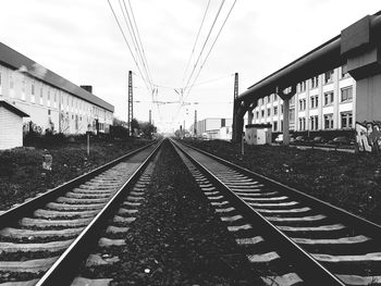 Railroad station platform in city against sky