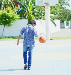 Rear view of boy playing with ball