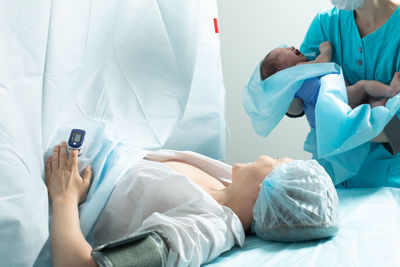 Midsection of doctor examining patient in hospital