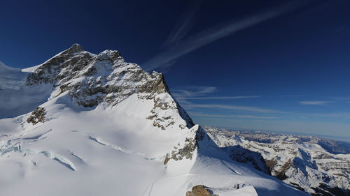 Scenic view of snowcapped mountains against blue sky