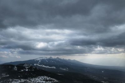 Scenic view of mountains against cloudy sky