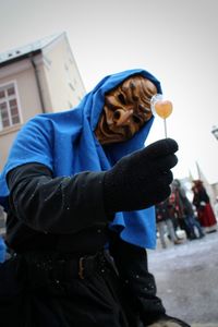 Person with mask showing candy on street