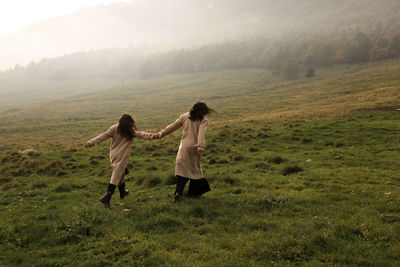 Rear view of women standing on field