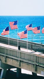 Scenic view of flag on beach against blue sky