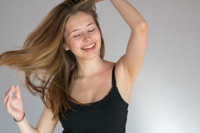 Portrait of smiling young woman against white background