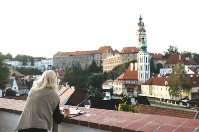 Rear view of woman painting on railing against st jost church in city