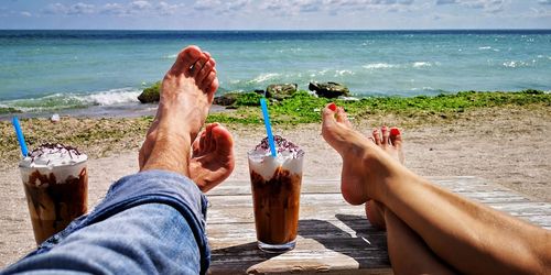 Low section of couple relaxing on beach