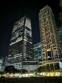 Low angle view of illuminated buildings against sky at night