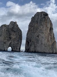 Rock formation in sea against sky