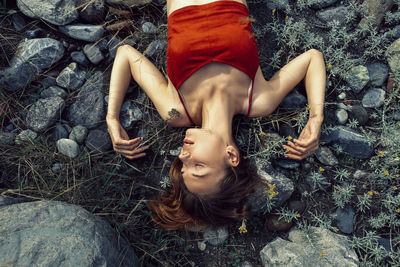 High angle view of woman sleeping on rocks