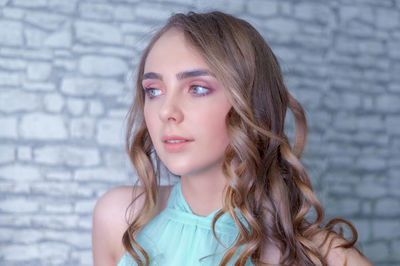 Portrait of woman against wall