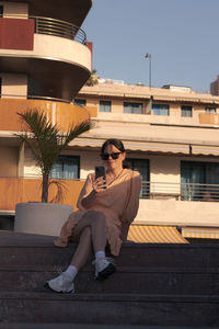 Woman sitting outside building