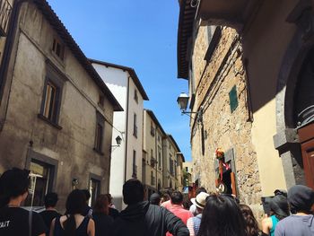 Crowd in city against clear sky
