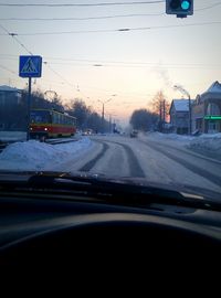 Cars on road against sky during sunset