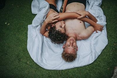 High angle view of couple lying on grass