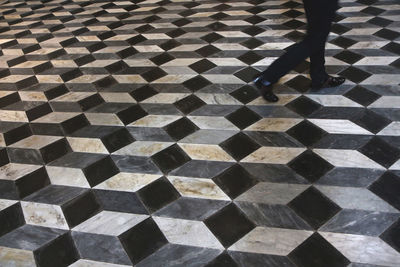 Low section of person standing on tiled floor