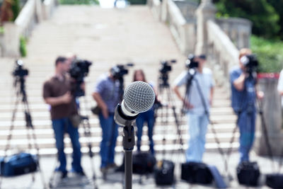 Close-up of microphone against people photographing outdoors