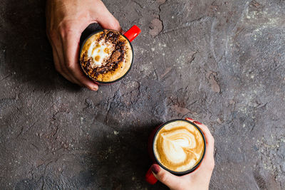 High angle view of hand holding coffee cup