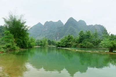 Scenic view of lake and mountains against clear sky