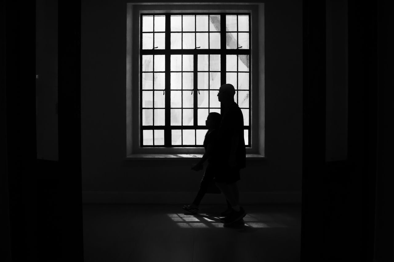 SIDE VIEW OF SILHOUETTE WOMAN STANDING AGAINST DOOR