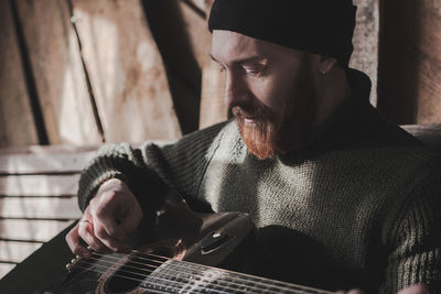 Midsection of man playing guitar