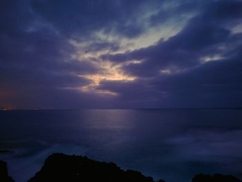 Scenic view of sea against storm clouds