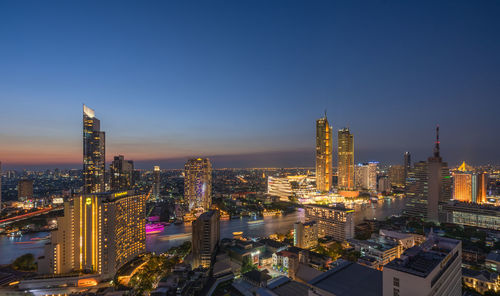 Illuminated buildings in city against sky