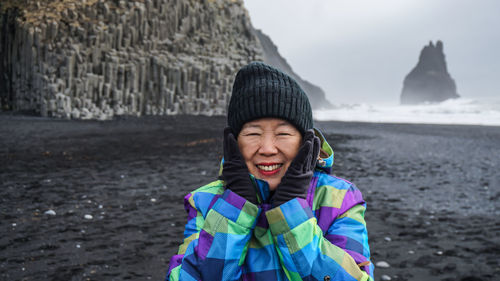 Portrait of smiling woman standing at beach