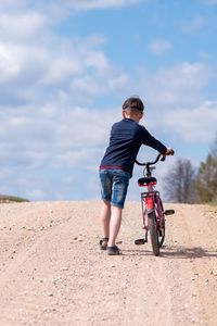 Full length of man riding bicycle on road