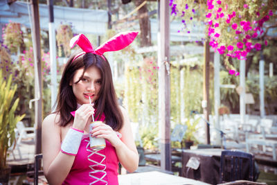Portrait of a beautiful woman in rabbit costume with drink