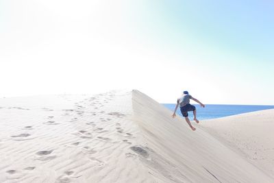 Full length of man on beach against clear sky
