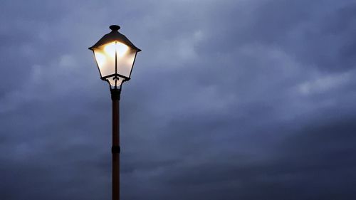 Low angle view of illuminated street light against sky