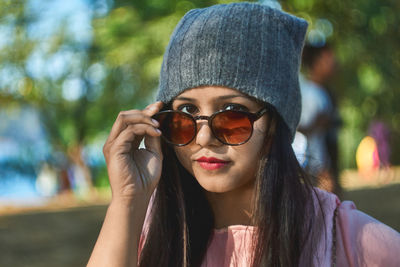 Portrait of young woman wearing sunglasses at park