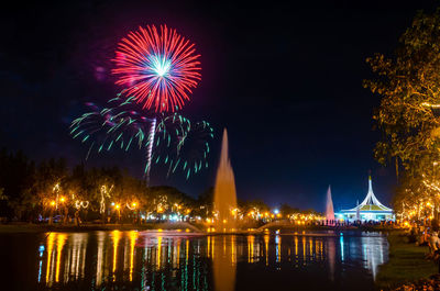 Firework display over river at night