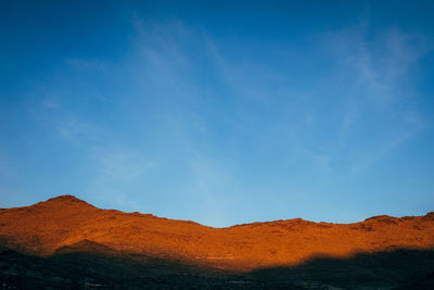 Scenic view of mountains against blue sky