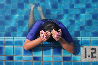 Man in swimming pool with head in hands