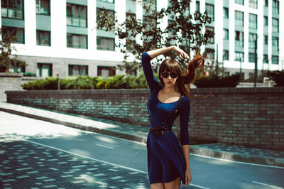 Young woman standing on street in city