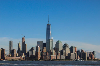 East river against one world trade center amidst towers in city