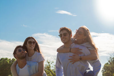 Group of young friends walking in a park while smiling - happy young group of friends