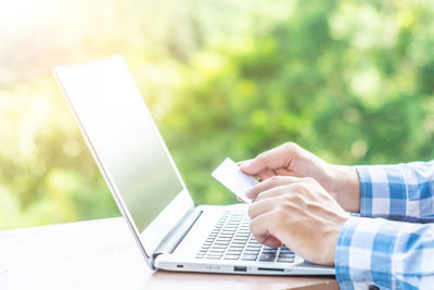 Cropped image of man doing online shopping at desk