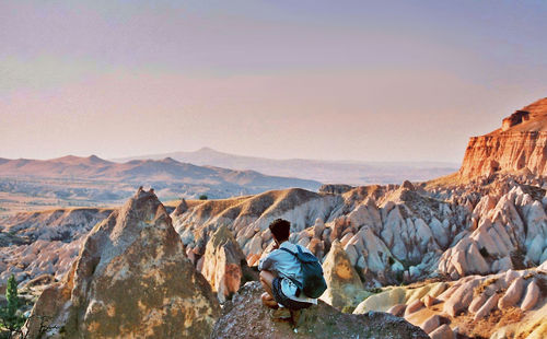 Rear view of man relaxing on cliff