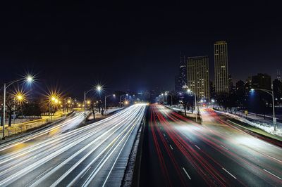 High angle view of white and red light trails on highway at night