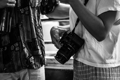 Midsection of woman holding camera