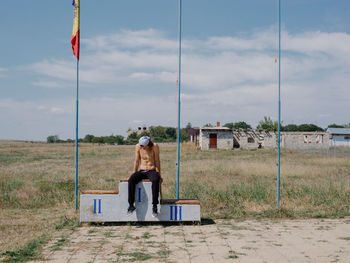 Rear view of siblings sitting on field